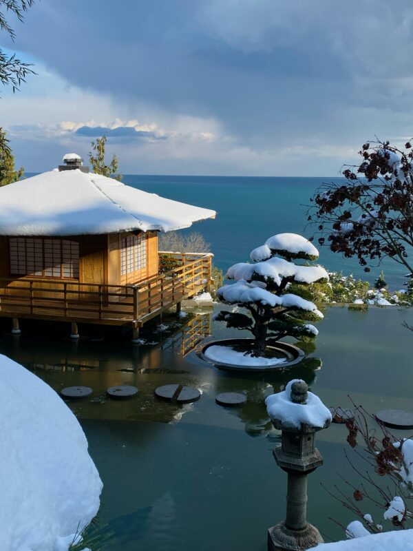 A snow-covered Japanese-style inn and the ocean viewed from one of the inn's rooms