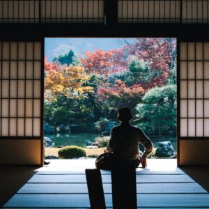 japanese person sitting in engawa temple